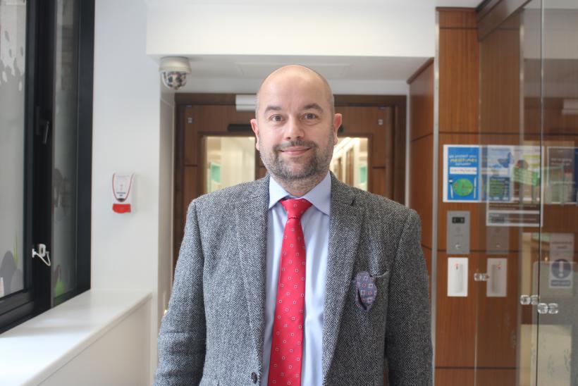 الطبيب الجراح مارتن كوستولني، استشاري جراحة القلب، واقفاُ في ممر داخل المستشفى