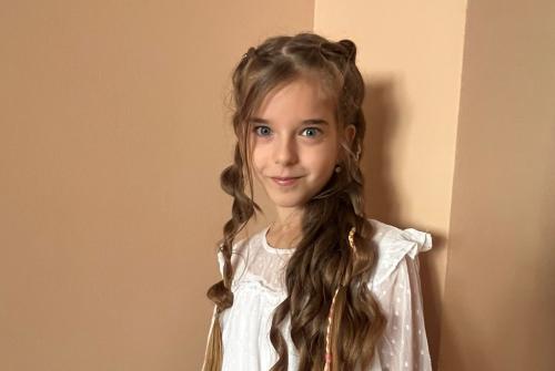 سارة من صربيا تظهر في الصورة وهي تقف أمام حائط أصفر اللون