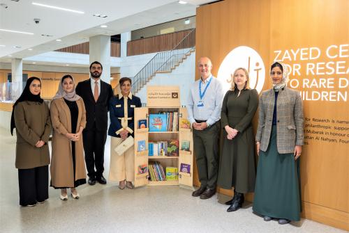 عدد من الأشخاص واقفون في شكل ضلعي مثلث ومبتسمون للكاميرا وورائهم لافتة مركز زائد للأبحاث على الحائط.