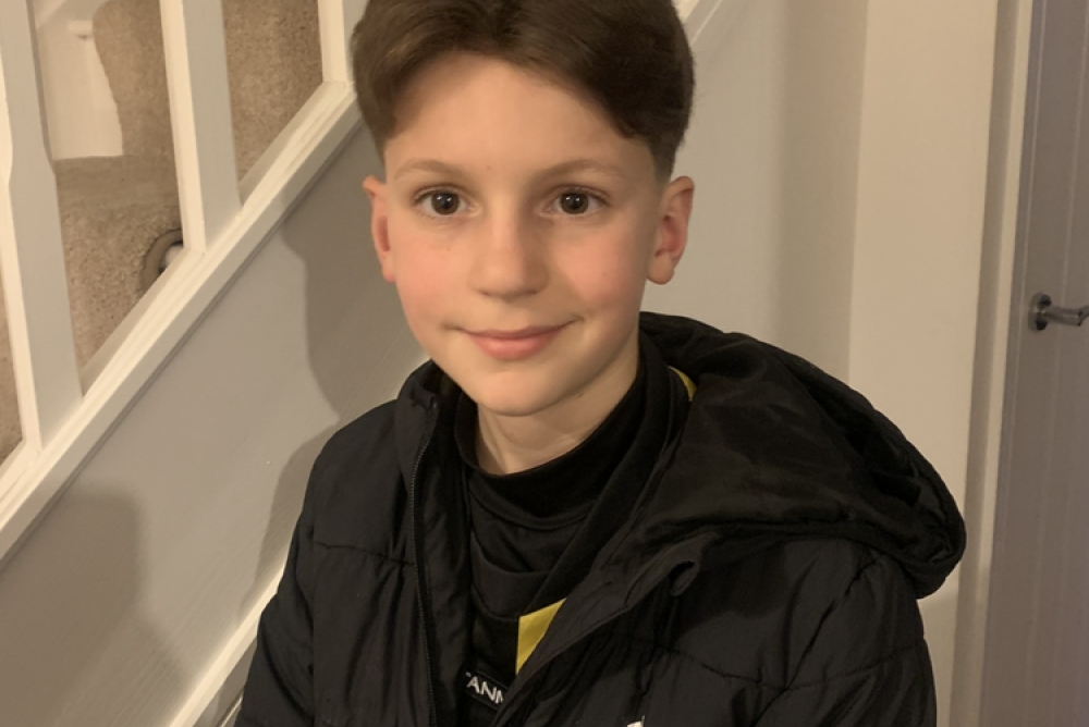 A photo showing Albert sitting next to a wooden white staircase